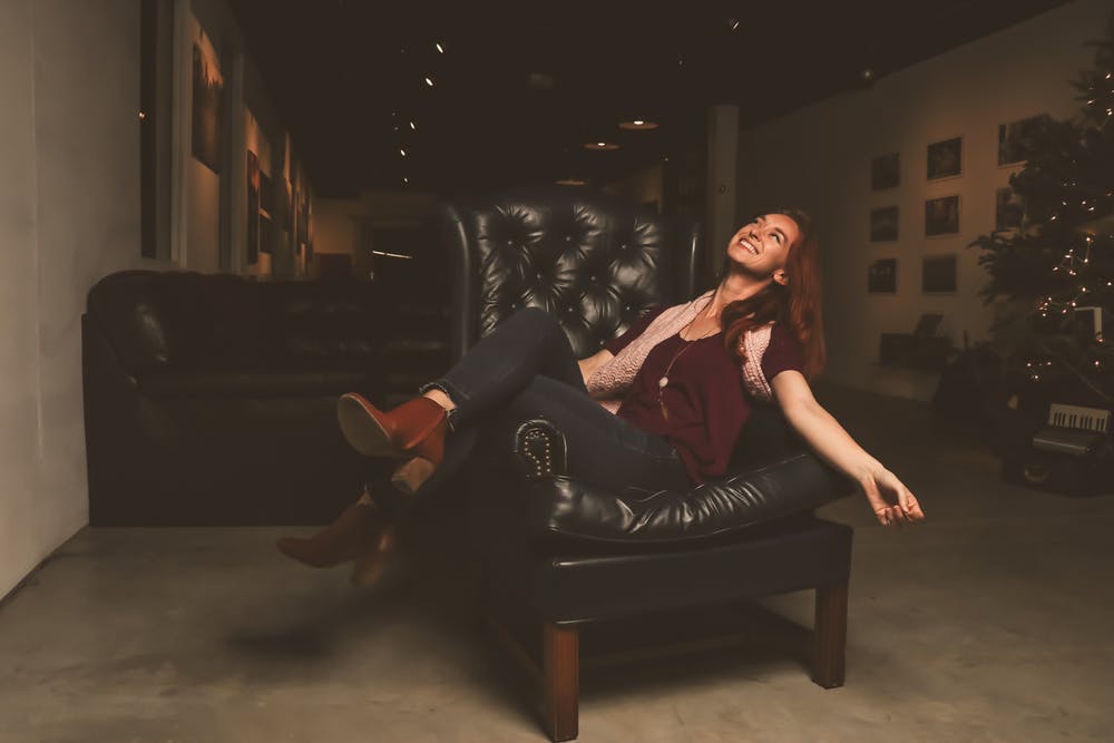 woman sitting in a black leather sofa